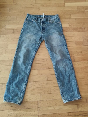 Weekday Klean - Säljer ett par blå jeans med rak passform från Weekday. Jeansen har fem fickor, knappgylf och är tillverkade i ett slitstarkt denimtyg. Perfekta för en avslappnad och tidlös stil. Storlek W31 L32