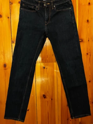 Mörkblå Jeans herr - Snygga mörkblå jeans med raka ben och klassiska kontrastsömmar. Märke: Cubus, Strlk: 30;32