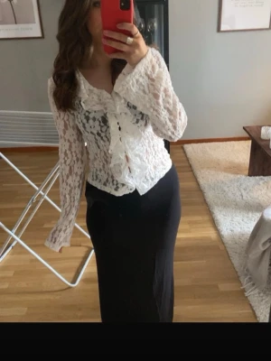 Vit spetsblus  - Säljer en superfin vit spetsblus från Vero Moda med långa ärmar och snygga volangdetaljer framtill. Blusen har v-ringning och är gjord i ett genombrutet spetsmaterial som ger en romantisk vibe. Perfekt att styla med både jeans och kjol!🥰