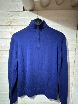 halvzip merinoulls tröja These Glory Days - Snygg blå stickad tröja från These Glory Days med halvzip och hög krage. Tröjan har lång ärm och är tillverkad i mjukt material som känns skönt mot huden. Perfekt för lager på lager och enkel att matcha med jeans eller chinos.
