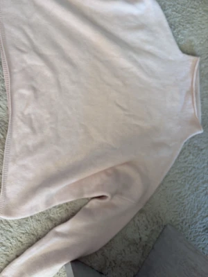 Ljusrosa polotröja från Lisa Yang - Supersnygg ljusrosa stickad polotröja från Lisa Yang. Tröjan har en hög krage och är gjord i mjukt material, perfekt för kyliga dagar. Enkel och stilren design som passar till allt. 