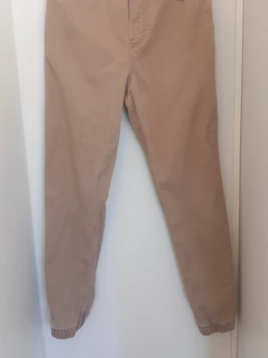 Beiga joggerbyxor med resår - Beige joggerbyxor från H&M i storlek 164. Mjuk och bekväm modell med resår i midjan och vid bensluten. Fickor fram och bak. Använda men i fint skick utan hål eller slitage. Supermjuka och sköna till vardags.
