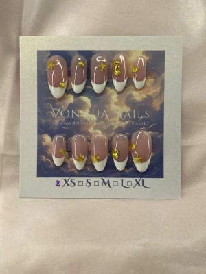 Positano (XS);Medium Almond - Snygga handgjorda press-on naglar i en medium lång mandelform med handmålad fransk vit tipp och nude bas. Dekorerade med sjöstjärnor mm. för en trendig look. Perfekt för dig som vill ha unika och handgjorda naglar. Finns i XS: 14 mm, 11 mm, 11,5 mm, 10 mm, 8 mm