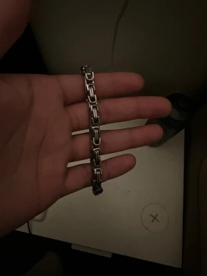 Herr armnbad  - Snyggt armband med robusta, rektangulära länkar i silverfärgad metall. Armbandet har en modern och stilren design som passar perfekt till streetwear eller en mer klassisk look. Länkarna ger ett coolt och industriellt intryck. Perfekt accessoar för dig som gillar detaljer.