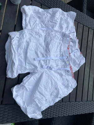 Vita shorts med snörning och knappar - Säljer två par vita shorts med snörning i midjan. Finns nån liten fläck                            60kr för båda