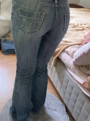 Vintage low waist och utsvängda jeans - Säljer dessa vintage jeans som är blå. Otroligt fina och unika fickor. Lite slitage ned till men annars i super fint skick. Skulle säga att storleken är S-M💗