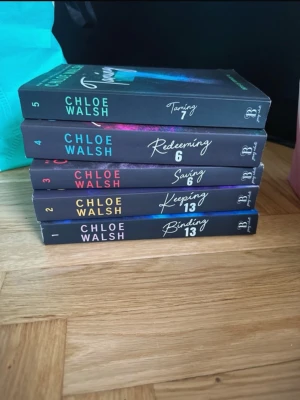 Chloe Walsh bokserie, Boys of tommen - Säljer en komplett uppsättning av Chloe Walshs populära bokserie med titlarna Binding 13, Keeping 13, Saving 6, Redeeming 6 och Taming 7. Böckerna har svarta omslag med färgglada detaljer och tydliga titlar på ryggen. Perfekt för dig som gillar romantisk och dramatisk skönlitteratur.