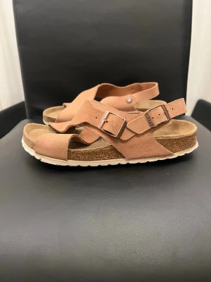 Birkenstock Tulum (Soft Footbed)Rosa, EUR: 39 - Snygga sandaler från Birkenstock i ljusrosa mocka med justerbara spännen i metall och vit räfflad sula. Anatomiskt utformad fotbädd i kork och öppen tådesign. Perfekta för en avslappnad och trendig look.