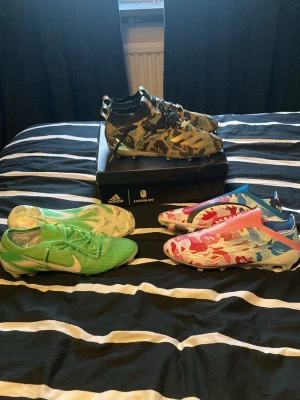 Adidas x BAPE elite och Nike elite fotbollsskor - Adidas x bape elite 44. Adidas x bape F50 elite 43. Nike superfly 360 Elite ”Naija” 43. Camo färgade skorna är snvönda en gång på konstgräse. Jag vet ej om f50 är äkta men de är köpta på kh kicks. De är helt nya. Nike skorna är köpta på vinted och saknar två dubbar men man kan fortfarande anvönda dem. Resten av dubbarna sitter hårt och som vanligt 