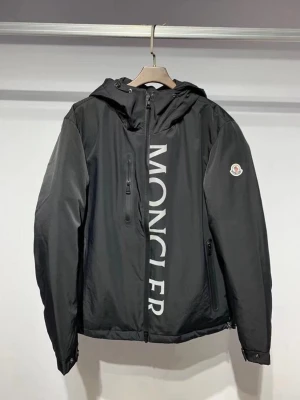 Svart vindjacka från Moncler - Snygg svart vindjacka från Moncler med stor logga i vitt längs dragkedjan och klassisk Moncler-patch på ärmen. Jackan har huva, dragkedjeförsedda fickor och en sportig look. Perfekt för dig som vill ha en stilren och trendig jacka.