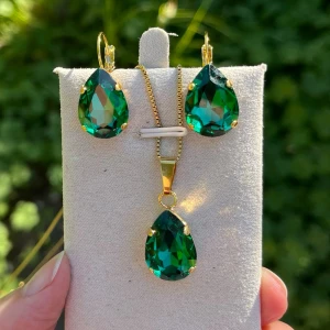 Set kristall örhängen halsband Emerald  - Ett set med halsband och örhängen med brisyrkrok i guldplätterad mässing och kristaller. Aurora pear 13x18mm färg Emerald. Längd 48cm inkl lås och förlängningskedja.  Finns även att få i andra färger på kristallen. Senare bilder visar andra färger som finns i lager.  Jag skickar endast spårbart, samfraktar. Fast pris. Besök gärna mina övriga annonser.  Till mina smycken använder jag kristaller från Preciosa, Aurora och Swarowski.