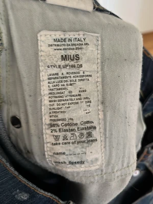Blå MIUS jeans från Dondup  - Säljer ett par blå MIUS jeans från Denham med snygg tvätt och slitningar. Jeansen har raka ben, två bakfickor med dragkedjedetaljer och är tillverkade i 98% bomull och 2% elastan. Perfekta för en avslappnad och trendig look. Storlek 35 men sitter som 32