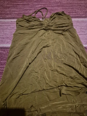 Olivgrön ärmlös linnetopp - Söt flowy top från Thailand stretchigt material som känns skönt mot huden. Perfekt för varma dagar och enkel att styla!