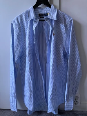 Blårandig skjorta från Polo Ralph Lauren - Kör rensning och känner att denna har gjort sitt för mig. Perfekt nu till sommaren, båten eller uteserveringen. Jag har inte använt den så mycket så väldigt bra skick förutom att den är skrynklig eftersom den legat i garderoben. Den är för dig som vill ha stil i sommar😎😊⛱️