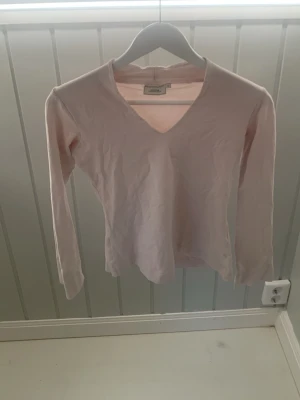  Boomerang V-ringad långärmad rosa tröja  - Ljus rosa V-ringad långärmad tröja. Slutet på ärmarna så är det uppklippt med mening lixom. 