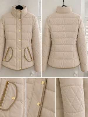 Beige pufferjacka med guldiga detaljer - Stilren beige pufferjacka med hög krage, guldiga knappar och dragkedjor på fickorna. Jackan har quiltade detaljer på ärmarna och en figurnära passform. Perfekt för kalla dagar och ger en snygg siluett.