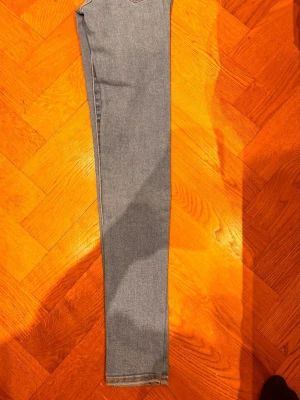 Levi's ljusblå skinny jeans W24 L30 - Säljer ett par klassiska ljusblå skinny jeans från Levi's med hög midja och ikonisk bakficka med den röda Levi's-taggen. Jeansen har smal passform och är tillverkade i mjukt denimtyg som sitter snyggt längs benen. Perfekta för en trendig och avslappnad look.