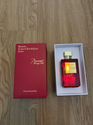 Baccarat Rouge 540 Extrait de Parfum - Lyxig parfym från Maison Francis Kurkdjian, Baccarat Rouge 540 Extrait de Parfum. Flaskan är elegant i rött glas med guldfärgat lock och etikett. Kommer i en snygg röd presentask med gulddetaljer. Perfekt för dig som gillar exklusiva dofter och vill ha något unikt i parfymhyllan.