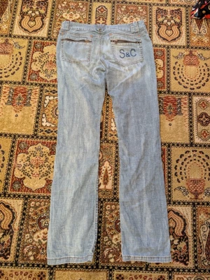 Ljusblå jeans från Staff & Co - Säljer ett par ljusblå jeans från Staff & Co med raka ben och klassisk femficksdesign. Jeansen har snygga kontrastsömmar, dragkedja och dubbla knappar i midjan. Bakfickan har en broderad S&C-logga. Perfekta till din vardagsstil! Passar någon som är 170 lång. 