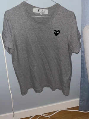 Comme des garcons T-shirt - Säljer denna gråa CDG T-shirten. Den är i nyskick och är bara använd två gånger. Köpt i Frankrike på LaFayette och kvitto finns. Inga skador eller tecken på användning. Vid frågor är det bara att skriva. //MVH LÉ