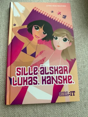 Sille älskar Lukas. Kanske. - En färgglad ungdomsbok med hårda pärmar, skriven av Astrid Heise-Fjeldgren. Omslaget har tecknade figurer i lila, rosa och beige toner. Boken handlar om vänskap, kärlek och hemligheter bland tonåringar. Perfekt för dig som gillar relationsdrama och tjejkompisar.