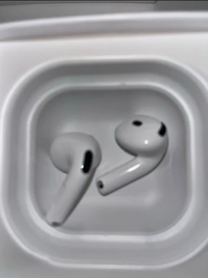 Vita trådlösa in-ear hörlurar - Säljer ett par vita trådlösa in-ear hörlurar från Apple med stilren design och laddningsetui. Hörlurarna har en slimmad form och är tillverkade i blank plast. Perfekta för musik, poddar och samtal på språng.