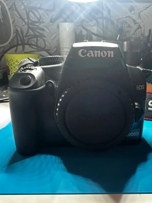 Canon EOS 1000D systemkamera - Canon EOS 1000D är en svart systemkamera med robust plastkropp. Kameran har tydliga knappar och en stor display på baksidan. Perfekt för dig som vill ta snygga bilder och utveckla ditt fotograferande med en pålitlig kamera från Canon. (Batteri och lins saknas)