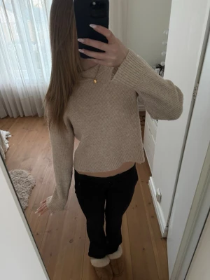 Beige ribbstickad tröja - Mysig beige ribbstickad tröja med rund hals och långa ärmar. Tröjan har en avslappnad passform och är tillverkad i ett mjukt, stretchigt material som känns skönt mot huden. Använd ett par gånger men inga skador eller defekter finns!