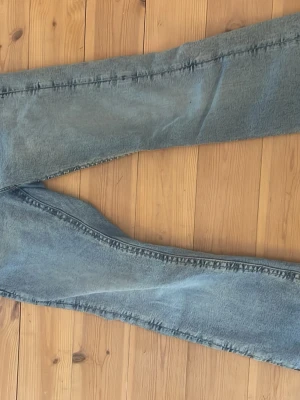 Blåa Gina tricot jeans - Ett par blåa jeans från Gina tricot i storlek 170, justerbar midja och en enkel design på fickorna, har dock ett litet skav på båda ändarna av benen ( se bild ) då de var lite för långa för mig innan fast sitter super bra i benen nu ( 160cm plus/minus e jag ) Pris kan diskuteras! 