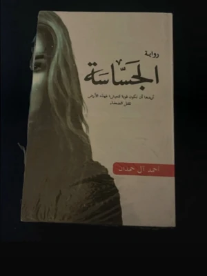 Romanen الحساسة av Ahmed Al Hamdan - En skönlitterär bok på arabiska med titeln الحساسة, skriven av Ahmed Al Hamdan. Omslaget är i beige och svart med en konstnärlig bild av en kvinna. Perfekt för dig som gillar romaner på arabiska och vill ha något unikt i bokhyllan.