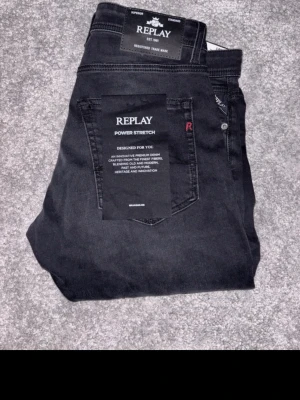 Replay svarta straight fit jeans - Snygga svarta jeans från Replay, modell Grover med straight fit och power stretch för extra komfort. Klassisk femficksdesign och diskret Replay-logga på bakfickan. Perfekta för dig som gillar stilrena och bekväma jeans.