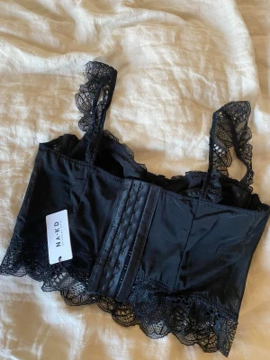 Spets topp/korsett - Svart spets topp/ korsett. Aldrig använd endast testad en gång, med lappen kvar. Storlek medium men funkar som en small också