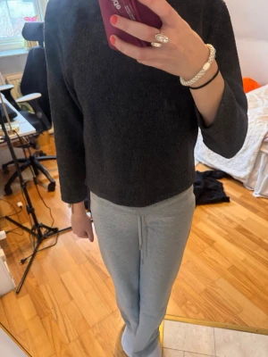 Mörkgrå basic tröja med 3/4-ärm - En enkel och stilren mörkgrå tröja med 3/4-ärm och rak passform. Tröjan är gjord i ett mjukt material som känns skönt mot huden och funkar perfekt till ett par mjukisbyxor eller jeans. Inga synliga loggor eller detaljer.