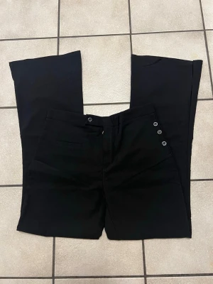 Svarta utsvängda jeans med knappar - Stretchiga byxor bootscut storlek L, Midja 76-82 cm, oanvända