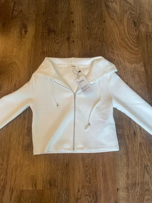 Vit hoodie med dragkedja  - Bra zip up tröja i storlek xs. Helt ny med prislapp, ej använd