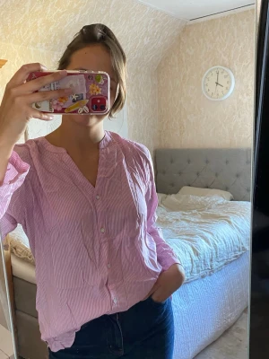 Rosa randig skjorta  - Rosa randig skjorta i 100% viskos, perfekt till sommaren. Från en dansk affär, märket b.young. Storlek 40, sitter lite oversized på mig som vanligtvis bär s/m. Aldrig använd med lappen kvar! Nypris 550kr.