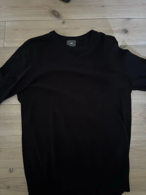 Svart slim fit tröja från H&M - En stilren svart tröja från H&M i slim fit-modell. Tröjan har rund halsringning och långa ärmar, perfekt för en clean och enkel look. Passar dig som gillar minimalistisk stil och vill ha något som funkar till det mesta.