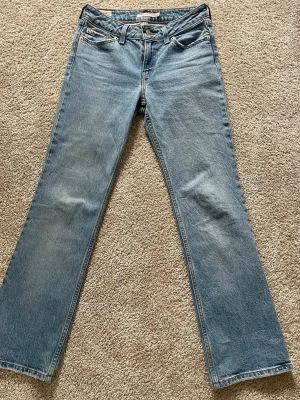 Levi's ljusblå raka/low pitch boot jeans - Ljusblå jeans från Levi's med klassisk rak passform/bootcut och femficksdesign. Jeansen har en snygg vintage-wash och är tillverkade i slitstark denim. Perfekta för dig som gillar en tidlös och avslappnad look.