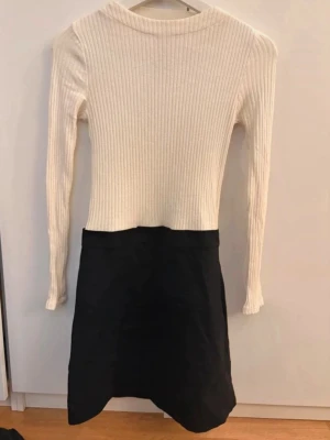 Vit och svart ribbad klänning MNG - Säljer en snygg tvåfärgad klänning från MNG med ribbad, långärmad överdel i vitt och svart kjoldel. Klänningen har en kroppsnära passform upptill och är kort i modellen. Perfekt för dig som gillar stilrena kontraster och enkel design.