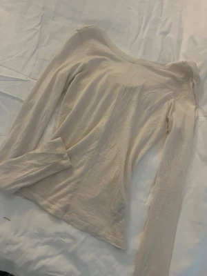 Genomskinlig topp från Carin Wester - En stilren beige långärmad topp med v-ringning. Tunt och lätt material som känns skönt mot huden. Perfekt att matcha med jeans eller kjol för en enkel och clean look. Genomskinlig! Från Carin Wester..