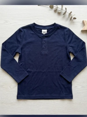 Ny tröja för barn - Säljer en stilren, mörkblå tröja som aldrig kommit till användning. Den har en djup och fin blå nyans som passar till allt. Tack vare GOTS-certifieringen kan du vara trygg med att plagget är fritt från giftiga kemikalier och producerat på ett miljövänligt sätt.  Färg: Mörkblå.  Storlek: 104/110 (GB: 4-5Y).  Material: 100% Ekologisk bomull.  Certifiering: GOTS (Global Organic Textile Standard).  Skick: Ny, aldrig använd/otvättad.  