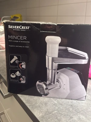 Köttkvarn SilverCrest med tillbehör - Elektrisk köttkvarn från SilverCrest i silver och svart. Kommer med flera tillbehör för olika malningsgrader och korvtillverkning. Maskinen är kompakt och har en modern design, perfekt för kökets bänkskiva.