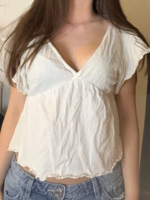 Vit v-ringad blus med volangärm - Supersöt vit blus med v-ringning och korta volangärmar. ❤️