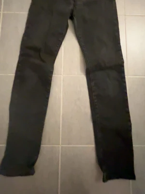 Svarta slim jeans från Weekday - Säljer ett par svarta slim fit 501 jeans från Levis . De har klassisk femficksdesign, knapp och dragkedja framtill samt raka ben. Materialet är bomull med lite stretch för skön passform. Perfekta för dig som gillar en enkel och stilren look. Storlek 30:32 pris kan diskuteras vid snabb affär!