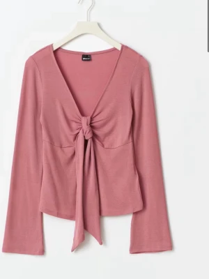 Rosa långärmad topp med knyt - Rosa omlotts topp  från gina tricot, liknande för design by si. Har inte använt den så många gånger , 2-3 gånger. Säljer pga att den inte kom till användning 💗
