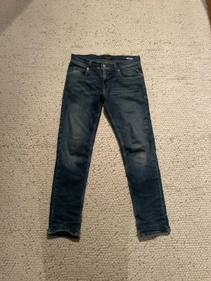 Blå slim fit jeans från Wrangler - Säljer ett par blå slim fit jeans från replay med klassisk femficksdesign och snygga slitningar. Jeansen har en normal midja och raka ben, tillverkade i mjukt och stretchigt denim-material. Perfekta för dig som gillar en tidlös och cool look. Passar ca 160-165. Priset kan diskuteras. Det går även att köpa alla 3 replay jeans på min profil för 900!