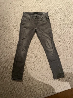 Gråa skinny jeans från Replay - Säljer ett par gråa skinny jeans från Replay med klassisk femficksdesign och svarta detaljer. Jeansen har smal passform och är tillverkade i stretchigt denimtyg för extra komfort. Snygga sömmar på bakfickorna ger en stilren look. De passar ca 160-165. Priset kan diskuteras. Det går även att köpa alla 3 replay jeans på min profil för 900!