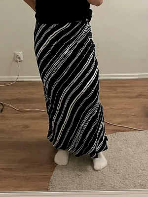 Randig maxi kjol - Marinblå och vit maxi kjol. Runt och luftigt material. Finns blixtlås på sidan. Har använts med försiktighet. Storlek 40, men skulle säga passar S/36 till L/40