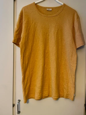East West Herrtshirt i stl Xxl fr Brothers  - Orangegulmelerad T-shirt i märket East West. Använd enstaka gång, inget att anmärka på. Finstickad i mjuk bomull (100%bomull). Normal i stl.
