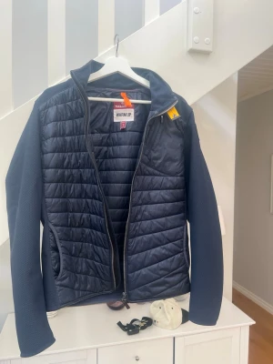 Parajumper cardigan - Snygg mörkblå pufferjacka från Parajumpers i modellen Warm Up. Jackan har quiltad framsida och släta ärmar i kontrasterande material. Dragkedja framtill och praktiska fickor. Perfekt för kalla vinterdagar och riktigt stilren look. Köpt på NK och har kvitto på varan
